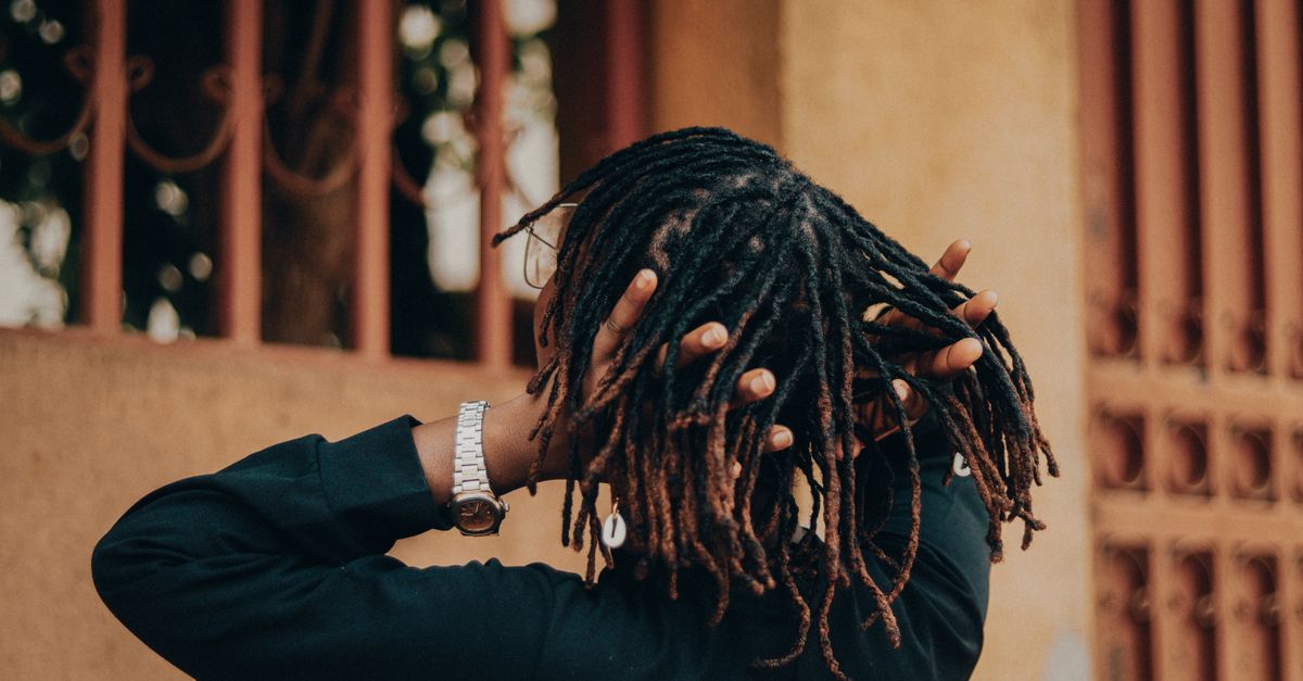 Person with dreadlocks styled in a fashionable manner, captures modern urban vibe.